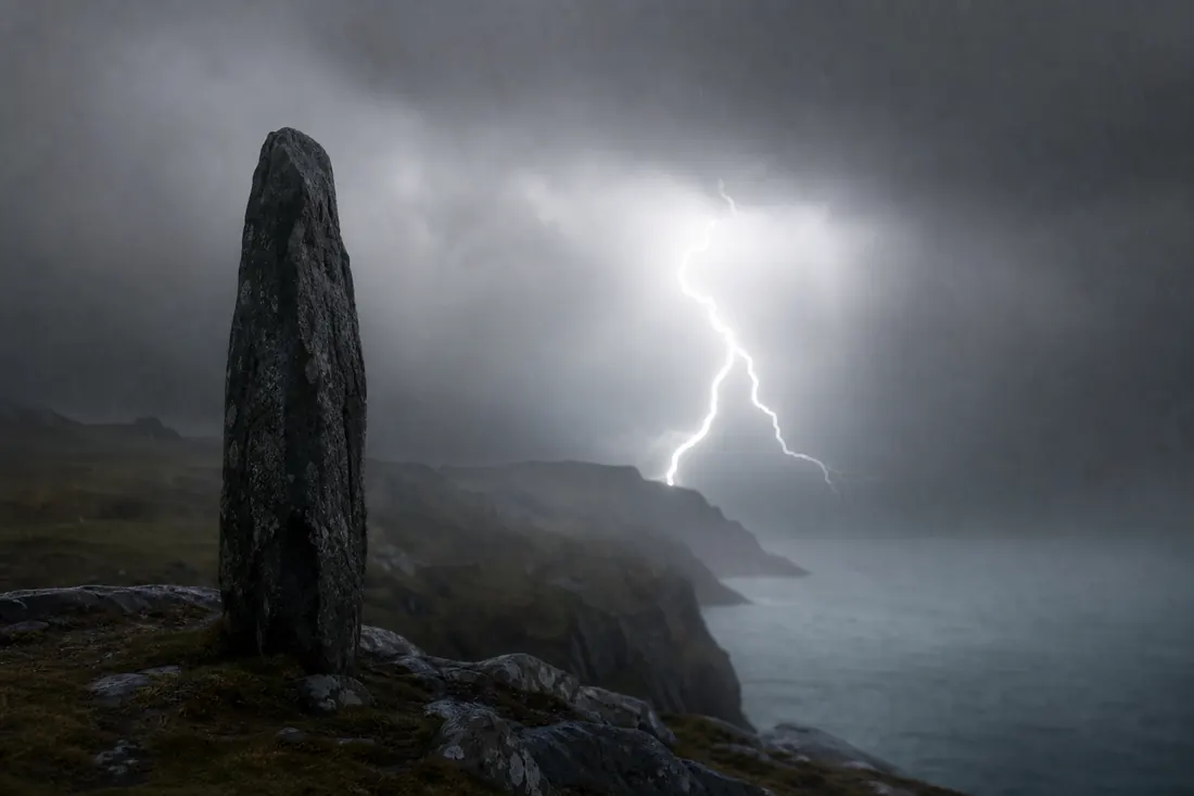 A storm sky and lightning bolt behind a lone weathered stone monolith